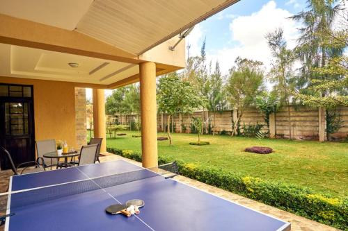 a ping pong table in the backyard of a house at The Cottage Residence Karen in Nairobi