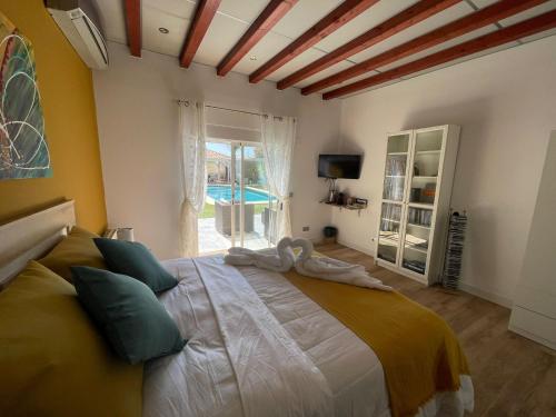 a bedroom with a large bed in a room with a pool at Habitación con baño privado frente a la piscina, máximo 2 Personas, no es la casa completa in San Vicente del Raspeig