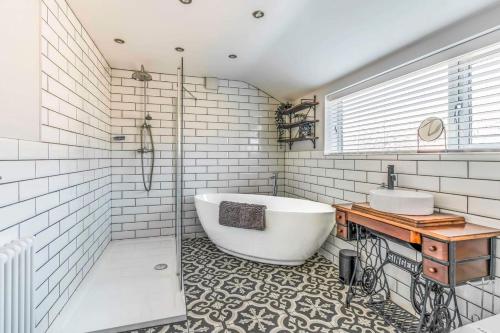 une salle de bain avec une grande baignoire et un lavabo dans l'établissement Ebenezer House, à Newbiggin-by-the-Sea