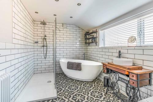 a bathroom with a large tub and a sink at Ebenezer House in Newbiggin-by-the-Sea