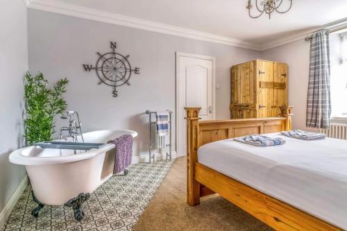 1 dormitorio con cama, bañera y bañera en Ebenezer House en Newbiggin-by-the-Sea