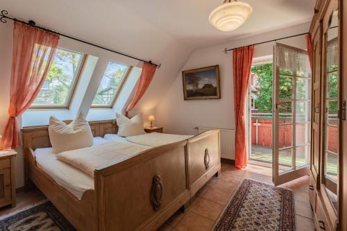 a bedroom with a wooden bed and windows at Ferienwohnungen am Bernsteinweg in Prerow