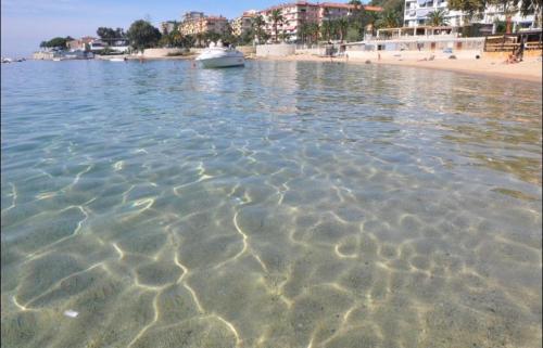 a body of water with a beach and a boat at Ajaccio magnifique T2 40m2 centre ville vue mer au bord de la plage neuf 5 personnes Clim wifi balcon parking privé fermé in Ajaccio