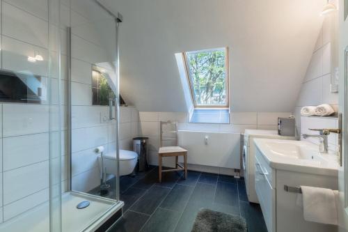 a white bathroom with a sink and a shower at Ferienwohnungen am Bernsteinweg in Prerow