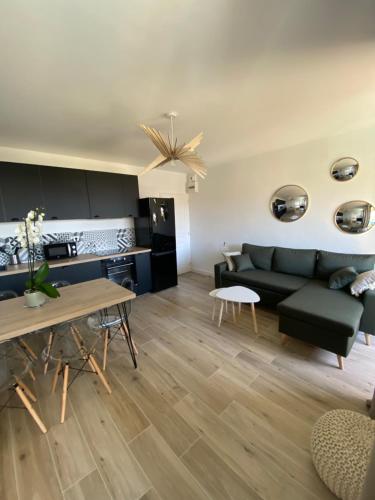 a living room with a couch and a table at Ajaccio magnifique T2 40m2 centre ville vue mer au bord de la plage neuf 5 personnes Clim wifi balcon parking privé fermé in Ajaccio