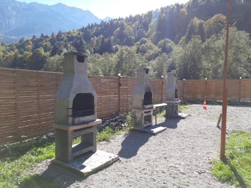 three large vases sitting next to a fence at Aroa Mountain in Zărneşti