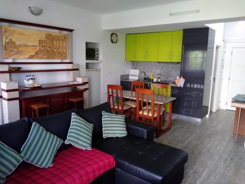 a living room with a couch and a table and a kitchen at Apartamento Balsa in Viseu