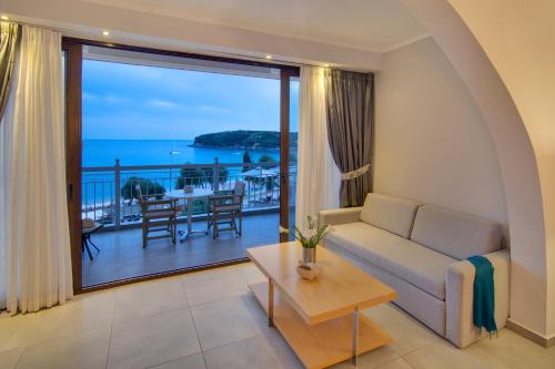 a living room with a couch and a view of the ocean at Valtos Beach Hotel in Parga