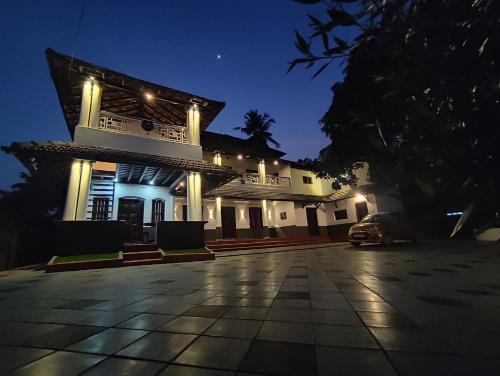a house with a car parked in front of it at night at SuKun Heritage in Kannur