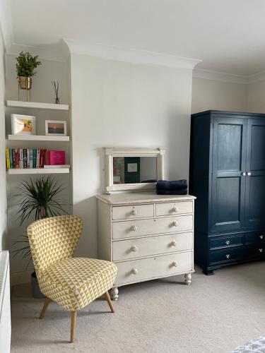 a bedroom with a dresser with a mirror and a chair at Period two-bed house, next to river and city in York
