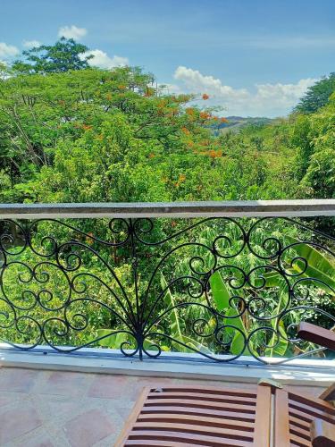 a balcony with a view of a forest at El Castillo Bed and Breakfast in Angono