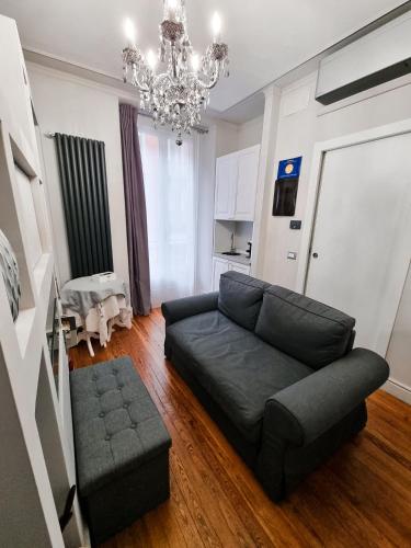 a living room with a black couch and a chandelier at b&b dolce casa con Sauna e cromoterapia in Domodossola