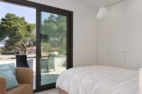 a bedroom with a bed and a sliding glass door at VILLA MANAVA in Llafranc