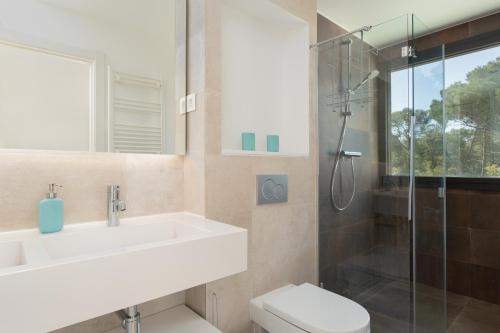 a bathroom with a sink and a toilet and a shower at VILLA MANAVA in Llafranc