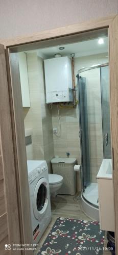 uma casa de banho com uma máquina de lavar roupa e um WC em Apartament w sercu Ciechocinka em Ciechocinek