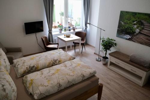 Kleines Zimmer mit einem Bett, einem Tisch und einem Schreibtisch. in der Unterkunft Gästehaus Langhals in Bad Segeberg