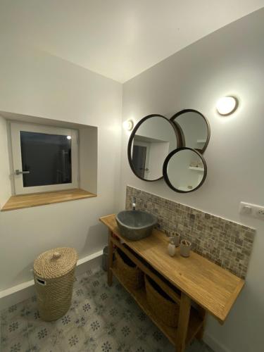 a bathroom with a sink and a mirror on the wall at La ferme de Valfons in Sauve