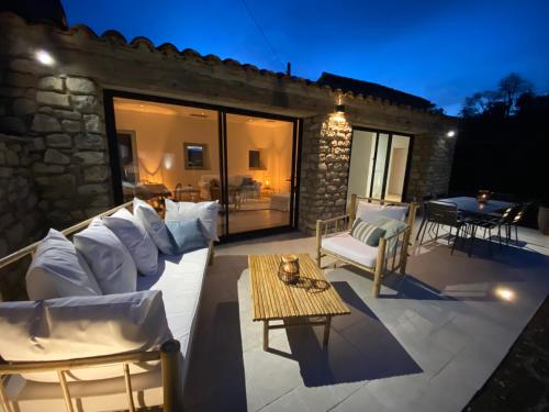 une terrasse avec un canapé blanc et une table dans l'établissement La ferme de Valfons, à Sauve