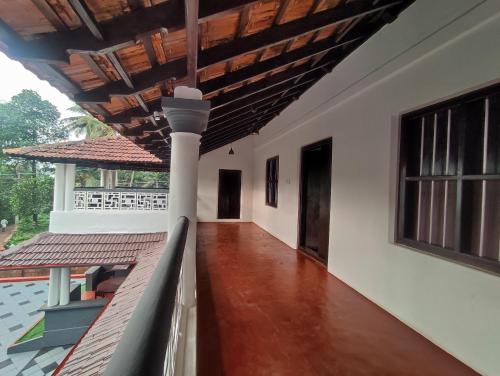 a corridor of a house with white walls and a wooden ceiling at SuKūn - Inhale Peace, Exhale Happiness in Kannur