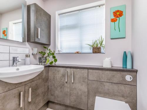 a bathroom with a sink and a mirror at Pass the Keys Charming Apartment Attached To Thatched Cottage in Chichester