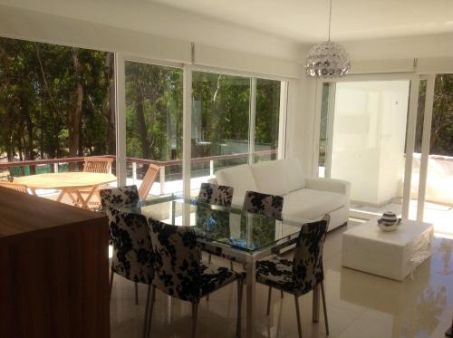 a living room with a glass table and chairs at Green Park Punta 2 in Punta del Este