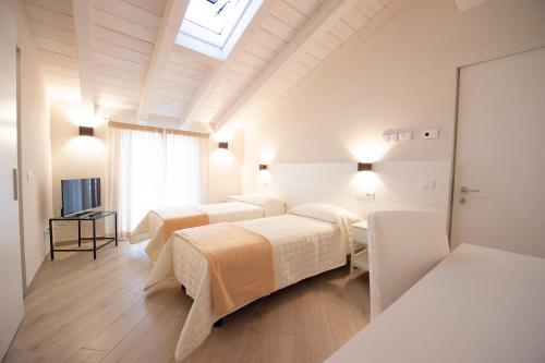 a room with three beds and a television at Villino Micol camere a due passi dal mare in Marina di Carrara