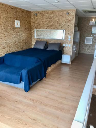a bedroom with a blue bed in a stone wall at Vistas al mar 4 Canabal in A Coruña