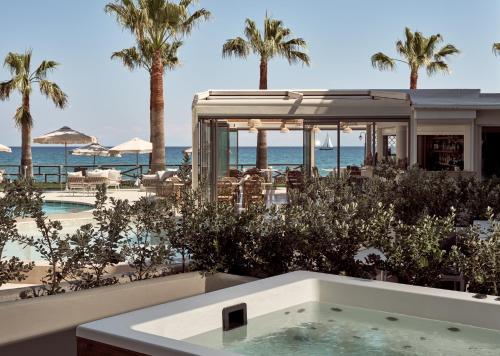 un jacuzzi en la playa con palmeras y el océano en Windmill Bay Hotel, en Argassi