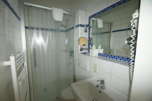 ヴァンガーオーゲにあるFerienwohnung 9 Rosenblatt - schönes Einraum Apartmentの白いバスルーム(シャワー、シンク付)