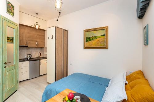 a living room with a blue bed and a kitchen at TAMO Rooms in Tbilisi City