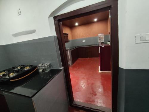 a kitchen with a stove and a red floor at SuKun Heritage in Kannur