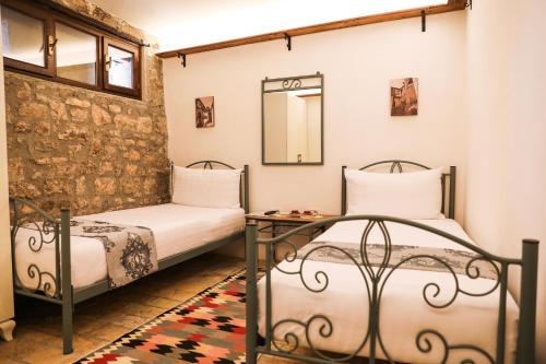 a bedroom with two beds and a mirror at The Well House - UNESCO in Berat