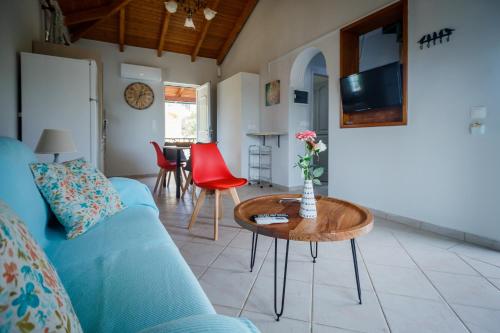 a living room with a blue couch and a table at Porto Gerakas Villas in Vasilikos