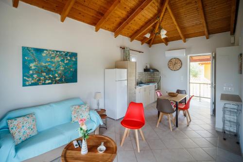 a living room with a blue couch and red chairs at Porto Gerakas Villas in Vasilikos