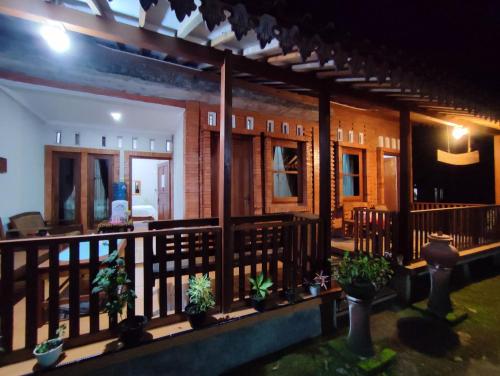 a house with potted plants on a balcony at night at Romadhoni Homestay in Magelang