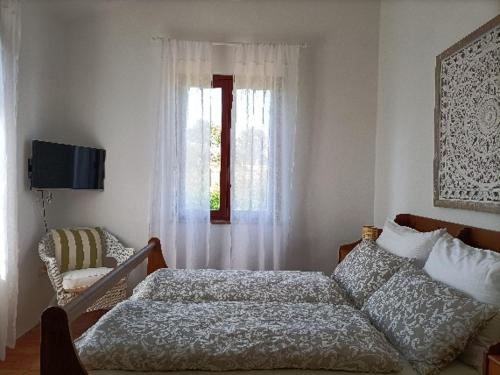 a bedroom with a bed and a chair and a window at Casale Il Girasole in San Costanzo