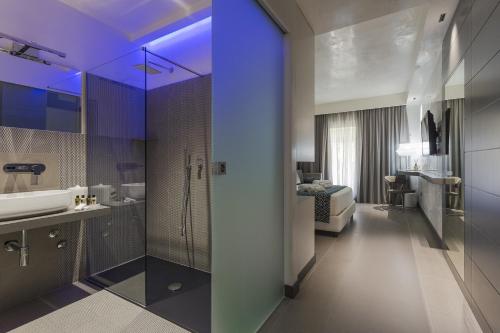 a bathroom with a sink, toilet, and bathtub at Caportigia Boutique Hotel in Syracuse