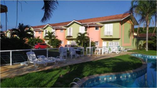 una casa con terraza con sillas y piscina en Casa na Praia de Maitínga - Bertioga - SP, en Bertioga