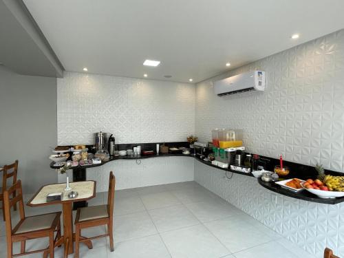 a kitchen with a counter and a table in a room at Hotel Beira Rio in Teófilo Otoni