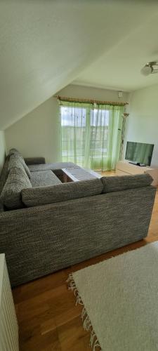 a large couch in a living room with a window at Juuli apartament in Kuressaare