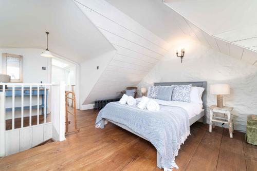 a white bedroom with a bed and a staircase at Secret Cottage in St Ives