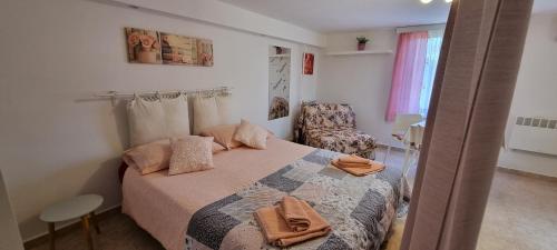 a small bedroom with a bed and a chair at App Maria 3 in Zambratija