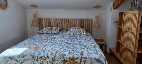 een slaapkamer met een bed met een blauw en wit dekbed bij Les Terrasses de L'Oliu de L'Oustalet in Castelsarrasin