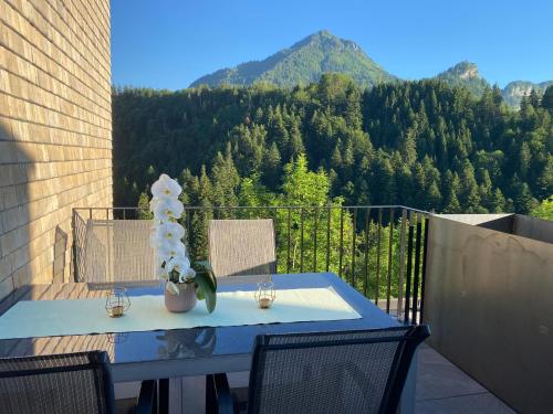 a blue table and chairs on a balcony with a mountain at Wohnung Staufenblick und Wohnung Firstblick in Dornbirn
