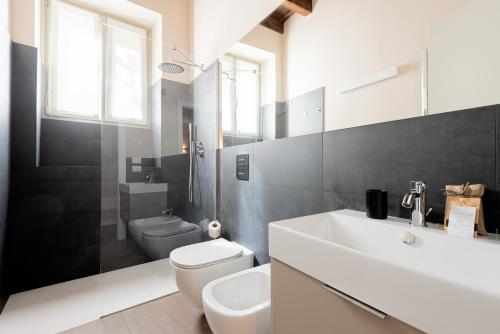 a bathroom with a white sink and a toilet at REGO APARTMENTS - Boutique Aparthotel with some off-site apartments in a Charming Historic District close to Upper Town in Bergamo