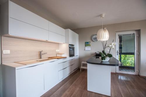 a kitchen with white cabinets and a black counter top at Sea View Apartments Debeli Rtič in Ankaran