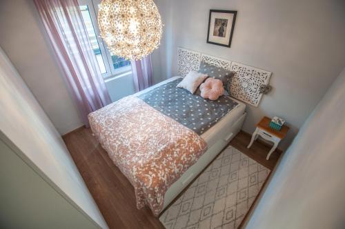 a small bedroom with a bed with a stuffed animal on it at Sea View Apartments Debeli Rtič in Ankaran