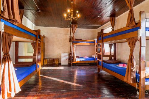 コトルにあるMontenegro Hostel 4Uの二段ベッド3組とシャンデリアが備わる客室です。