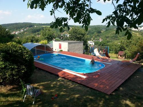 a swimming pool on top of a wooden deck at Penzion ALICE in Zlín