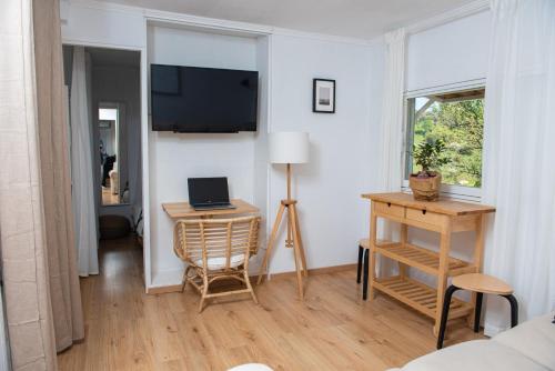 ein Wohnzimmer mit einem Schreibtisch und einem Laptop auf einem Tisch in der Unterkunft Grand Seaview Retreat - walk to the beach in Néoi Epivátai